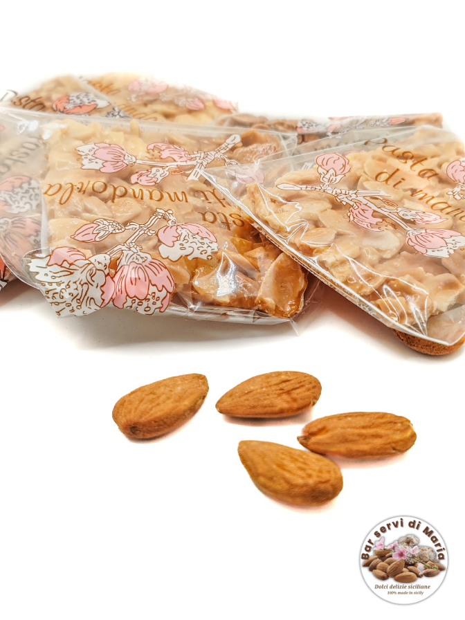 Torroncini sfoglia confezionati singolarmente dolci delizie siciliane su sfondo bianco e mandorle su sfondo